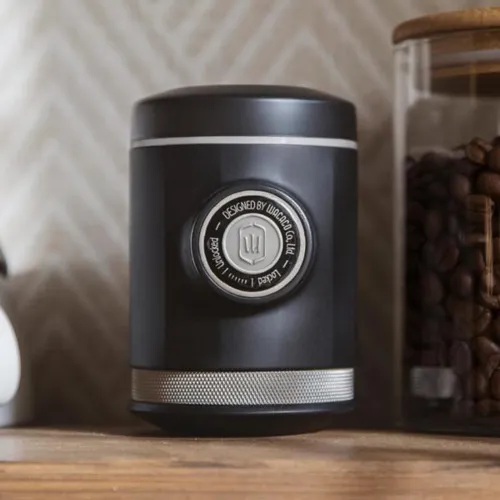 Picopresso on a wooden kitchen bench with a glass storage container full of coffee beans
